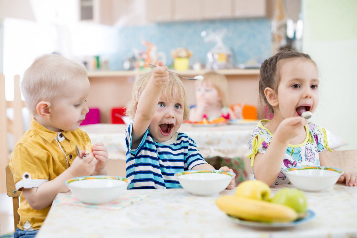 Funny little kid playing and eating in kindergarten